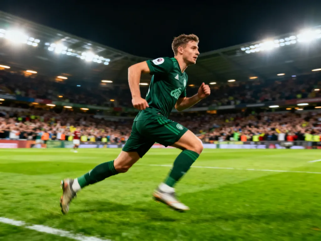 Vinícius Júnior biegnący z piłką po murawie stadionu podczas profesjonalnego meczu piłkarskiego.